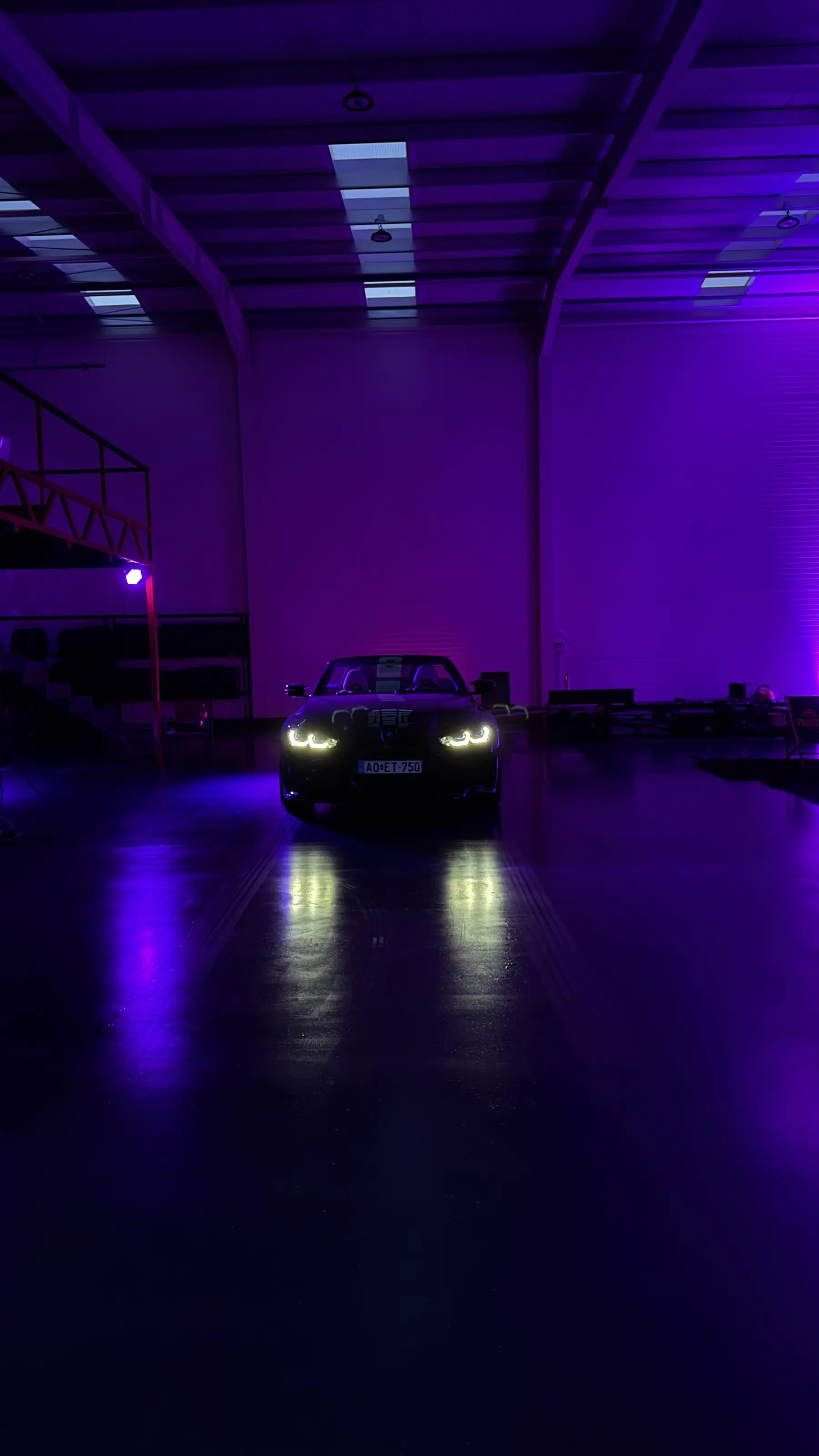 A The Garage műhelye éjszaka, lila világítás alatt álló BMW M4-gyel